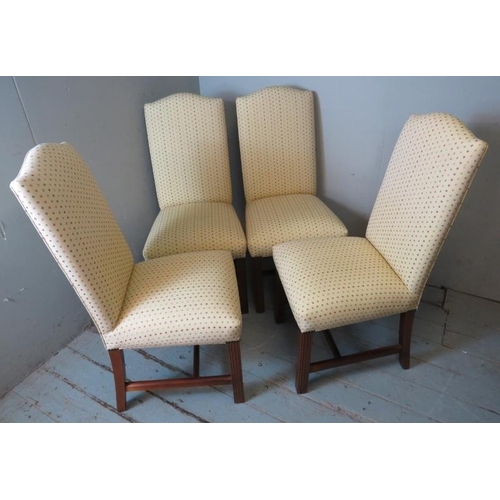 823 - A set of of four contemporary dining chairs upholstered in a cream patterned fabric, raised on reede... 