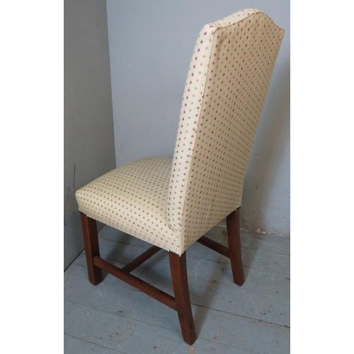 823 - A set of of four contemporary dining chairs upholstered in a cream patterned fabric, raised on reede... 