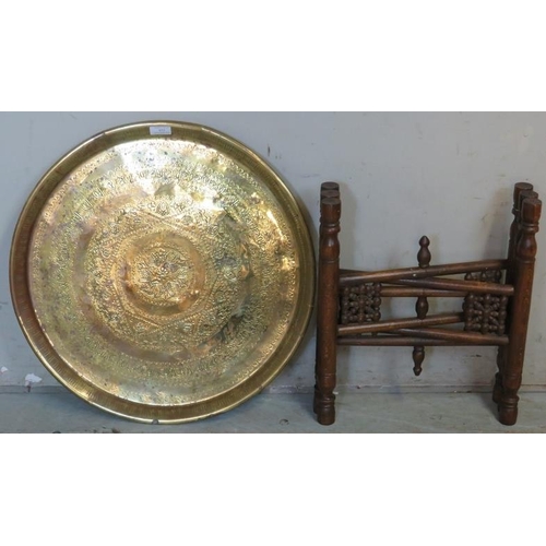 855 - A vintage brass Benares table with hand hammered tray top, raised on a hexagonal folding hardwood st... 