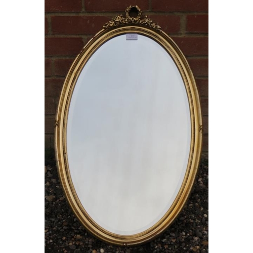 858 - A vintage bevelled oval gilt framed wall mirror with moulded foliate decoration to cornice.
Conditio... 