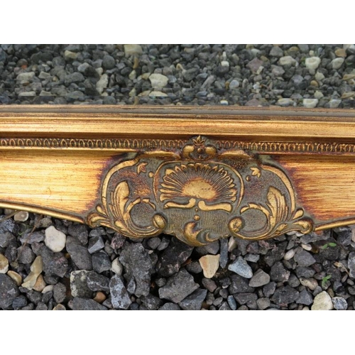 890 - A reproduction antique style bevelled rectangular wall mirror in an ornate gilt gesso frame.
Conditi... 