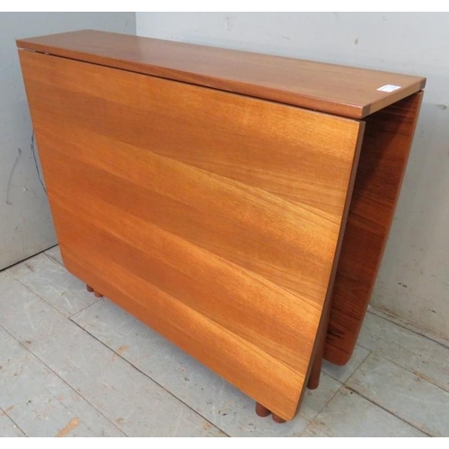 896 - A mid century teak drop leaf dining table by McIntosh raised on cylindrical supports, together with ... 