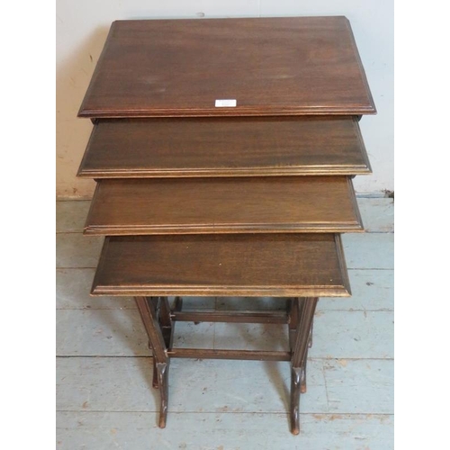 903 - An Edwardian mahogany quartet of nesting tables raised on reed supports with openwork lattice side s... 