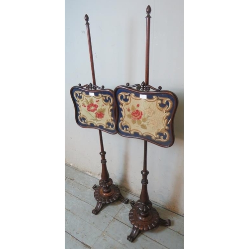 905 - A pair of 19th century mahogany pole screens with tapestry panels raised on baluster turned pedestal... 