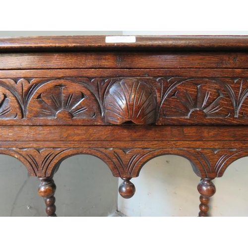 906 - A 19th century style carved oak side table in the Flemish taste with single frieze drawer, raised on... 