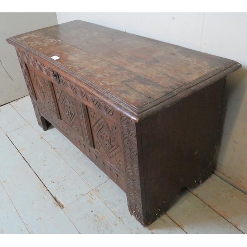 916 - An 18th century oak coffer of small proportions with internal candle box and carved decoration to fr... 