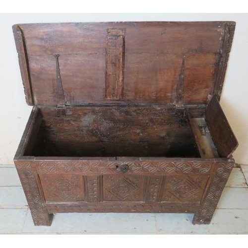 916 - An 18th century oak coffer of small proportions with internal candle box and carved decoration to fr... 