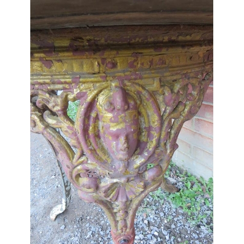 937 - A 19th century cast iron Britannia pub table with an oak top over an ornate cast iron base, raised o... 