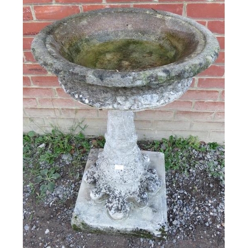 938 - A nicely weathered reconstituted stone bird bath raised on graduated column with shaped base.
90cm h... 