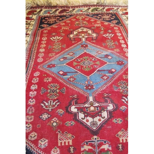 952 - A 20th Century Iranian rug with central blue motif on red ground and cream border. 140cm x 100cm.
Co... 