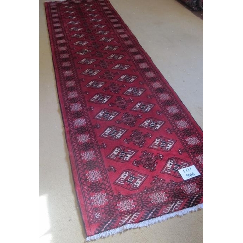 966 - A fine Persian Turkman runner repeated pattern highlighted in cream on claret ground. 305cm x 82cm.