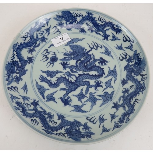 15 - An antique Chinese porcelain blue and white charger depicting a pearl chasing dragon within a four d... 