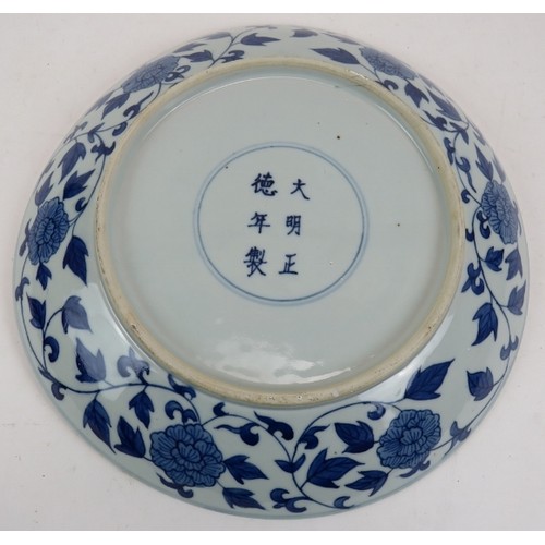 15 - An antique Chinese porcelain blue and white charger depicting a pearl chasing dragon within a four d... 