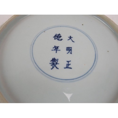 15 - An antique Chinese porcelain blue and white charger depicting a pearl chasing dragon within a four d... 