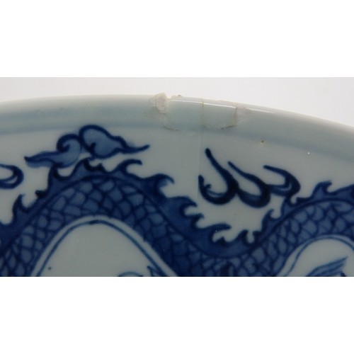 15 - An antique Chinese porcelain blue and white charger depicting a pearl chasing dragon within a four d... 