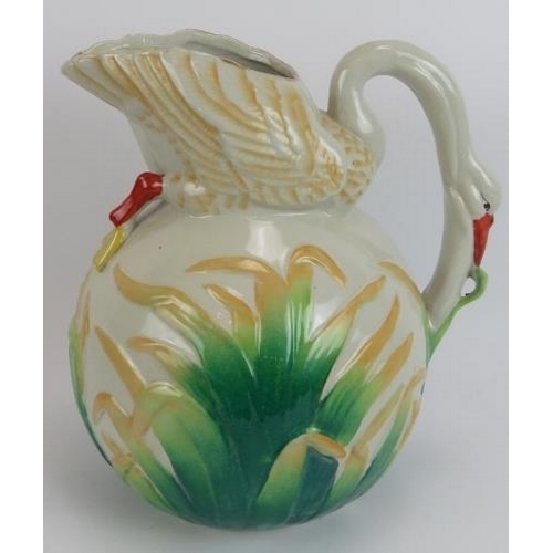 143 - A large Majolica style jug in the form of a feeding swan, a cockerel platter, a fruit decorated bowl... 