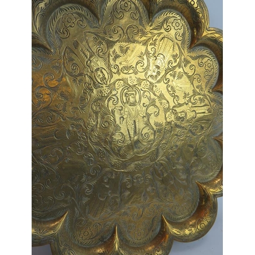 246 - An antique brass Indo Persian tray with scalloped edges and hand chased decoration plus a similar Is... 