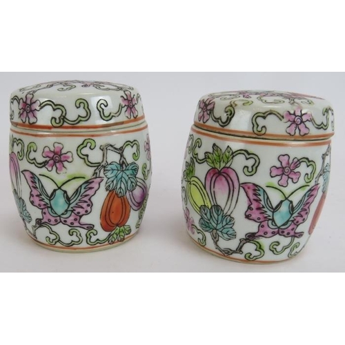 291 - A pair of small hand decorated Chinese covered jars, each with an erotic scene painted inside the li... 