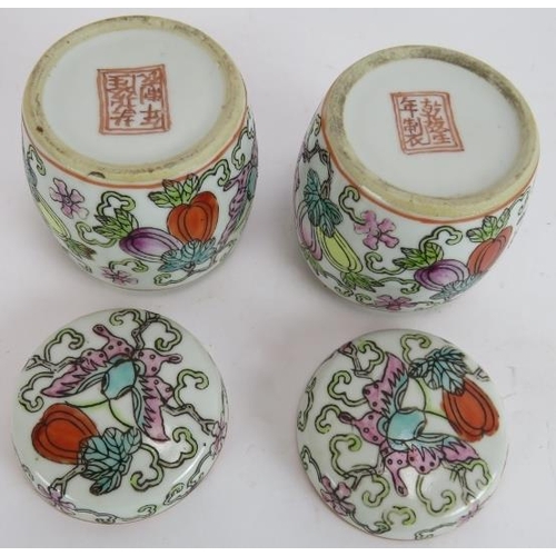 291 - A pair of small hand decorated Chinese covered jars, each with an erotic scene painted inside the li... 