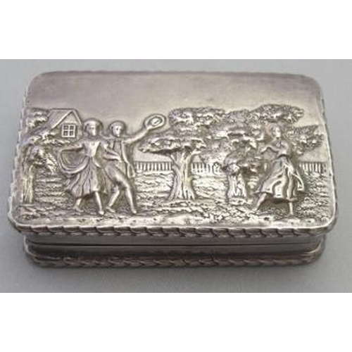 311 - A silver snuff box with gilded interior and the top heavily embossed with dancers & musicians, Londo... 