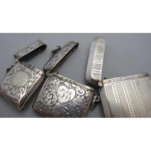 313 - A collection of three silver vesta cases, two engraved with foliate design and one engine turned, tw... 