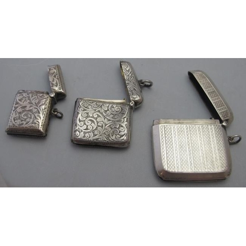 313 - A collection of three silver vesta cases, two engraved with foliate design and one engine turned, tw... 