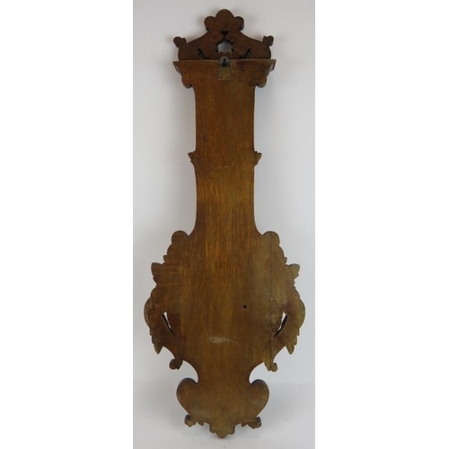 39 - An Edwardian carved oak barometer by T.B Winter & Son, Newcastle Upon Tyne, with deeply carved acant... 