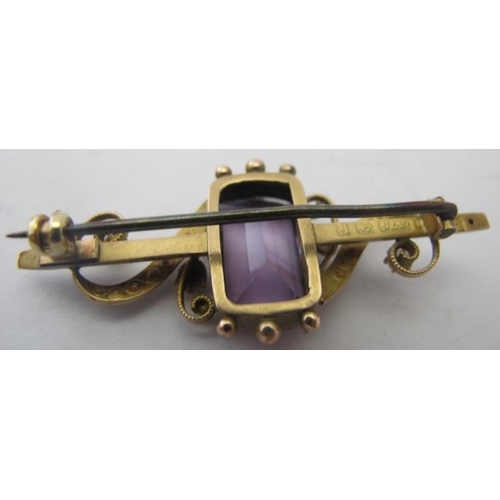 417 - A 9ct yellow gold Edwardian brooch set with large centre amethyst and two scrolls of graduated seed ... 