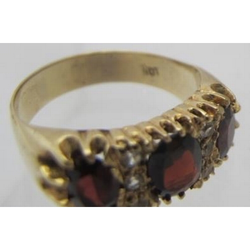 423 - A 9ct yellow gold ring set with three oval claw set garnets and white stones, centre garnet approx 8... 