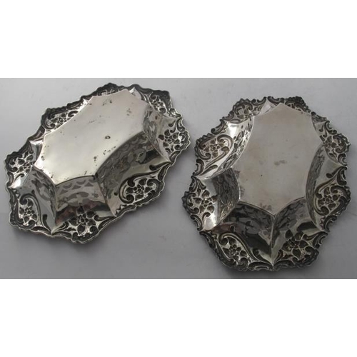 464 - A pair of oval silver bon bon dishes, heavily embossed with scrolls & flowers and pierced decoration... 