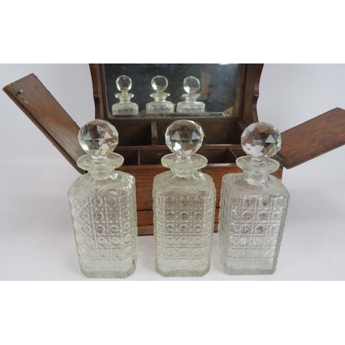 47 - A late 19th century oak tantalus box with three decanters, silver plated mounts, glass compartments ... 