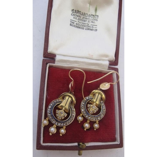 486 - A pair of diamond unmarked yellow metal drop earrings, having circles of 24 diamonds and an inner bl... 