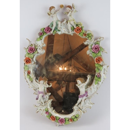 52 - A German porcelain Rococo style mirror decorated with various Putti and roses. Bears the mark of Pla... 