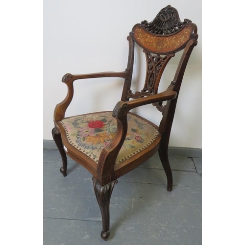 705 - A fine Edwardian mahogany elbow chair, featuring an intricately carved and pierced backrest with mar... 