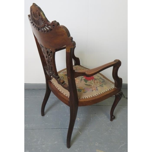 705 - A fine Edwardian mahogany elbow chair, featuring an intricately carved and pierced backrest with mar... 