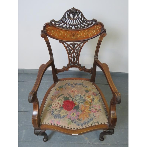 705 - A fine Edwardian mahogany elbow chair, featuring an intricately carved and pierced backrest with mar... 