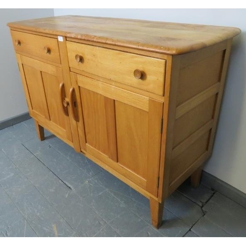 711 - A mid-century Ercol style blond elm and beech sideboard of two short drawers over a double cupboard,... 