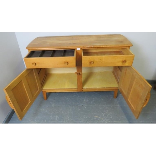 711 - A mid-century Ercol style blond elm and beech sideboard of two short drawers over a double cupboard,... 