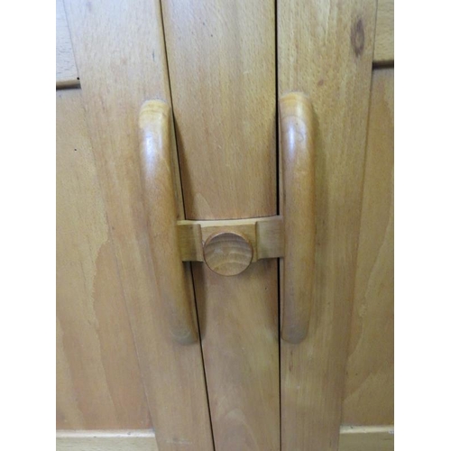 711 - A mid-century Ercol style blond elm and beech sideboard of two short drawers over a double cupboard,... 