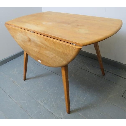 712 - A mid-century Ercol blond elm circular drop-leaf dining table, on canted tapering supports.
Conditio... 