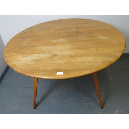 712 - A mid-century Ercol blond elm circular drop-leaf dining table, on canted tapering supports.
Conditio... 