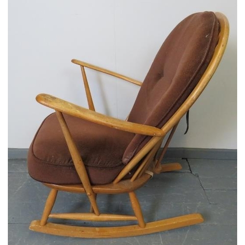 718 - A mid-century Ercol blond Windsor rocking chair, with loose seat cushions in brown draylon. 
Conditi... 