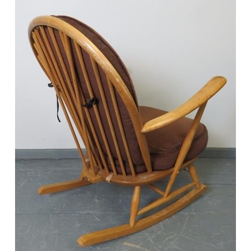 718 - A mid-century Ercol blond Windsor rocking chair, with loose seat cushions in brown draylon. 
Conditi... 