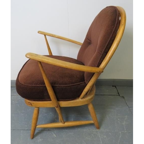 719 - A mid-century Ercol blond Windsor 334 armchair, with loose seat cushions in brown draylon. 
Conditio... 