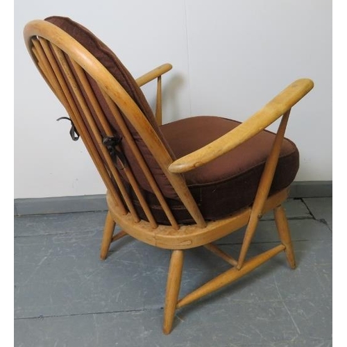 719 - A mid-century Ercol blond Windsor 334 armchair, with loose seat cushions in brown draylon. 
Conditio... 