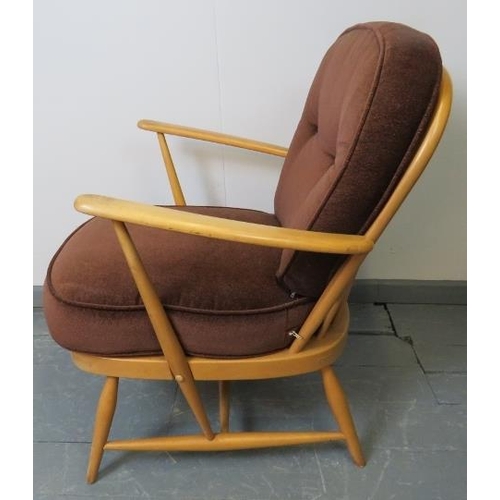 720 - A mid-century Ercol blond Windsor 335 armchair, with loose seat cushions in brown draylon. 
Conditio... 