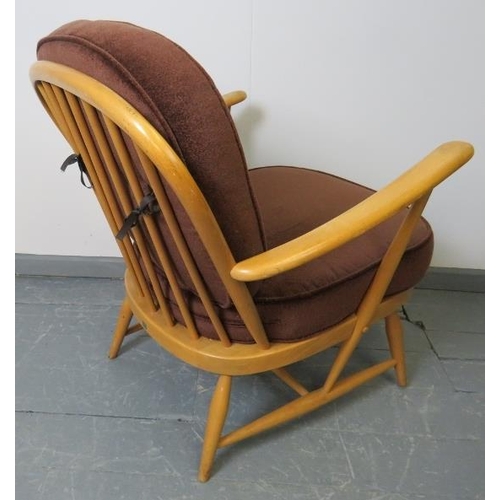 720 - A mid-century Ercol blond Windsor 335 armchair, with loose seat cushions in brown draylon. 
Conditio... 