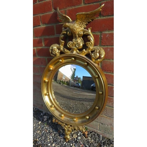 724 - A 19th century style giltwood convex mirror with ornately carved cornice depicting foliate motifs an... 