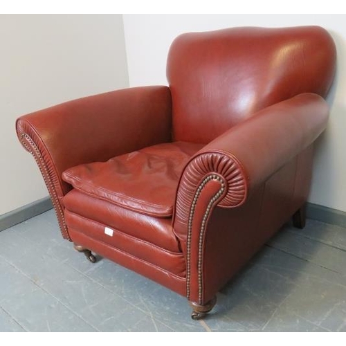 727 - A Victorian style club armchair, upholstered in deep grained brown leather with brass studs, on tape... 