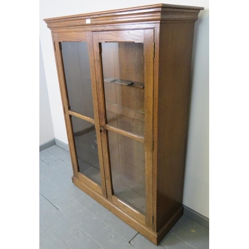 741 - A 19th century oak gun cabinet, with glazed doors opening onto a rack with provision for 6 shotguns.... 